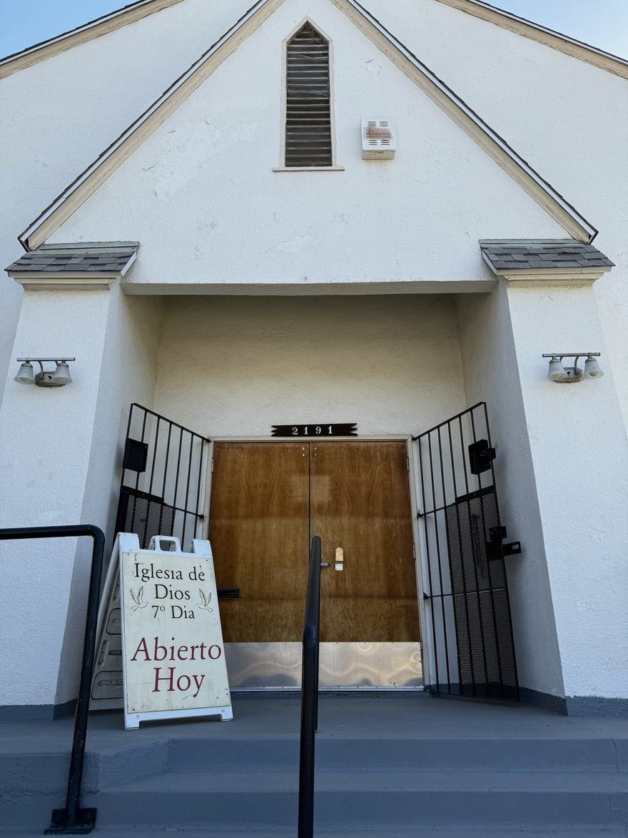 Front entrance of the church at 2191 South Eunice Ave, with an Abierto Hoy sign out front